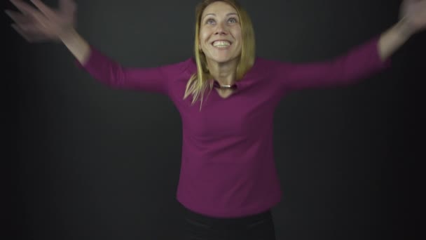 excitada dama en púrpura levanta las manos con felicidad en el estudio
 - Metraje, vídeo