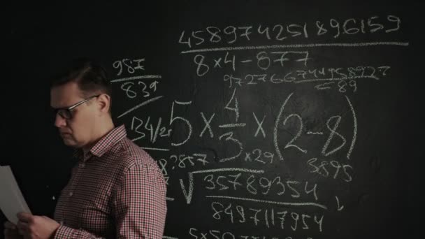 muž píše matematický vzorec na tabuli - Záběry, video