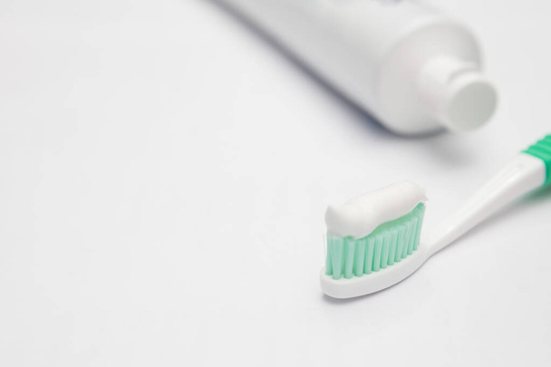 Tubo de cepillo de dientes y pasta de dientes sobre un fondo blanco
 - Foto, Imagen