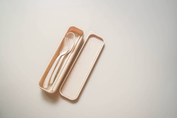 tenedor ecológico de vista superior aislado, cuchara y palillos en una caja práctica para comer y sostenible
 - Foto, Imagen