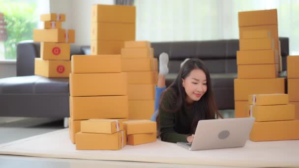 видео красивой азиатской женщины со стопками коробок, делающих бизнес дома во время карантина
 - Кадры, видео