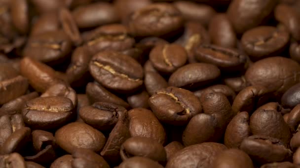 Geroosterde bruine koffiebonen, stapel koffiebonen draaiend in slow motion. - Video