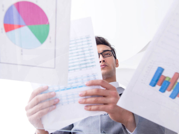 Businessman looking at financial charts and graphs - Фото, изображение