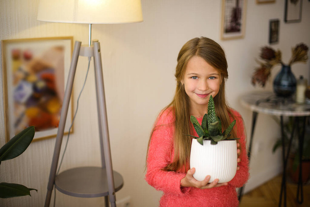 girl caring for domestic plants in the room. Quarantine at home - Photo, image