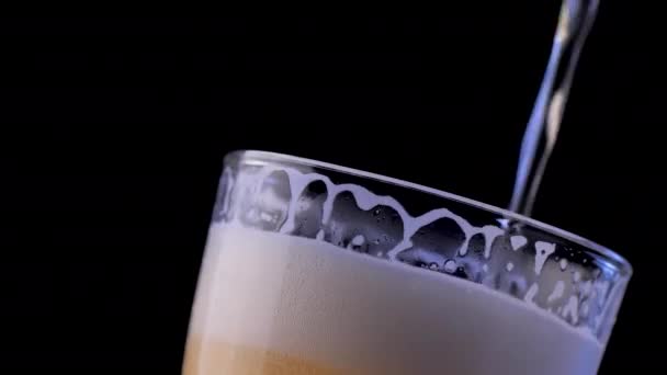 Close-up filling the beer into clear glass. The foam of the beer flows down to the edge of the glass - Séquence, vidéo