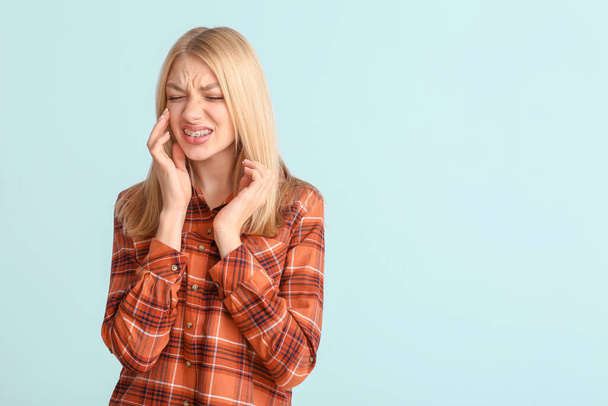 Stresszes nő fogszabályzóval színes háttér - Fotó, kép