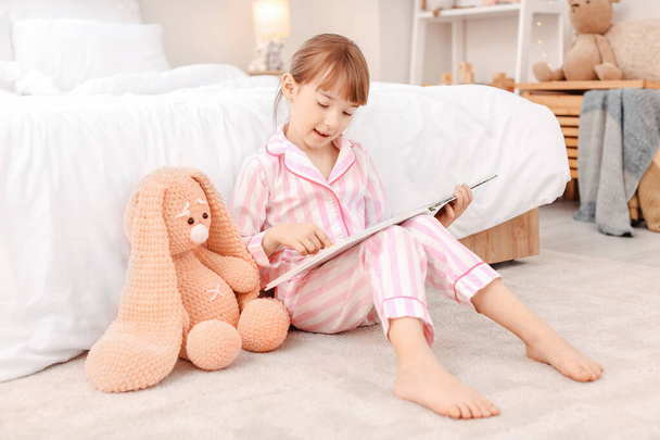 Cute little girl czytanie bajki przed snem w domu - Zdjęcie, obraz