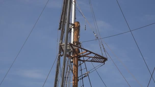 Wooden mast of sailboat with viewing platform at top, rope ladders and rope equipment - Footage, Video