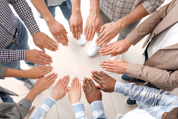 Group of people putting hands together indoors, top view. Unity concept - Photo, Image