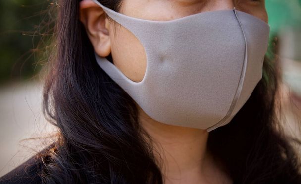 Ασιάτισσα νεαρή γυναίκα φορώντας μια προστατευτική μάσκα υγιεινής πάνω από το πρόσωπό της.Υγεία και πρόληψη ασθενειών από το coronavirus, covid 19 - Φωτογραφία, εικόνα