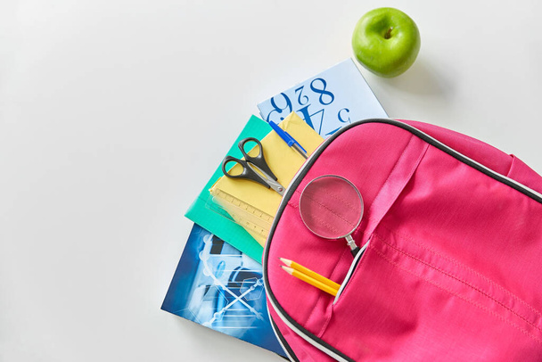 Rucksack mit Büchern, Schulmaterial und Äpfeln - Foto, Bild