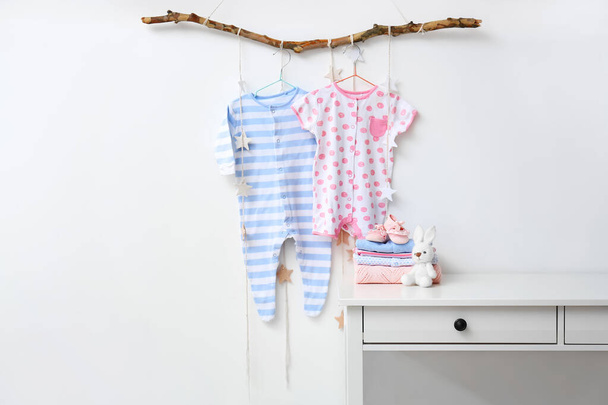 Baby clothes with booties and toy in room - Photo, Image