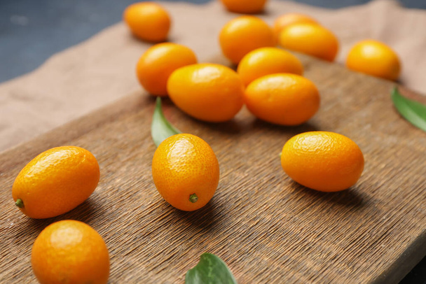 Tablero con sabrosa fruta kumquat, primer plano
 - Foto, Imagen