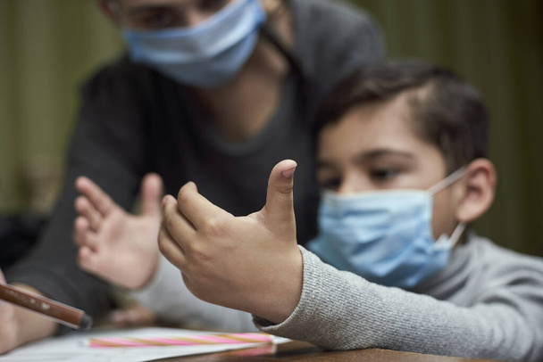 Distance education. Mother helps pre-school kid to do lessons. Education at quarantine time. Protection of Children during the Coronavirus Pandemic - 写真・画像