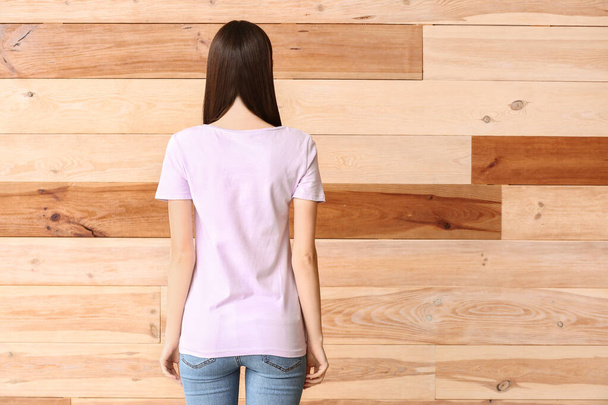Женщина в стильной футболке на деревянном фоне
 - Фото, изображение