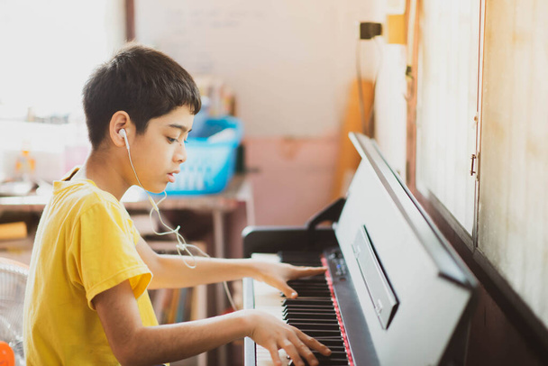 Мальчик учится играть на фортепиано онлайн
 - Фото, изображение