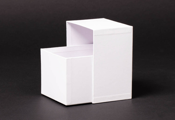 Caixa branca em branco aberta isolada em um fundo preto
 - Foto, Imagem