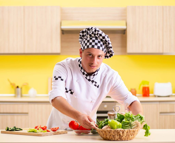 młody profesjonalny kucharz przygotowanie sałatki w kuchni - Zdjęcie, obraz