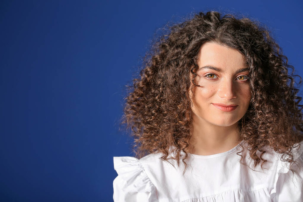 Young woman with beautiful curly hair on color background - Foto, Imagem