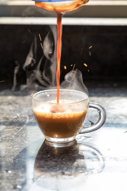 steamy masala tea being poured into a transparent glass cup - Φωτογραφία, εικόνα