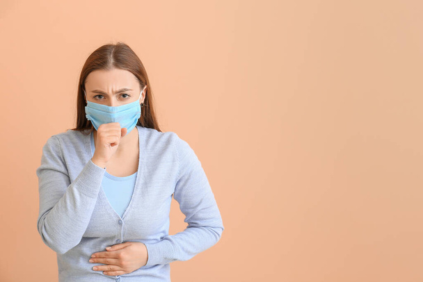Zieke vrouw met beschermend masker op kleur achtergrond. Begrip epidemie - Foto, afbeelding