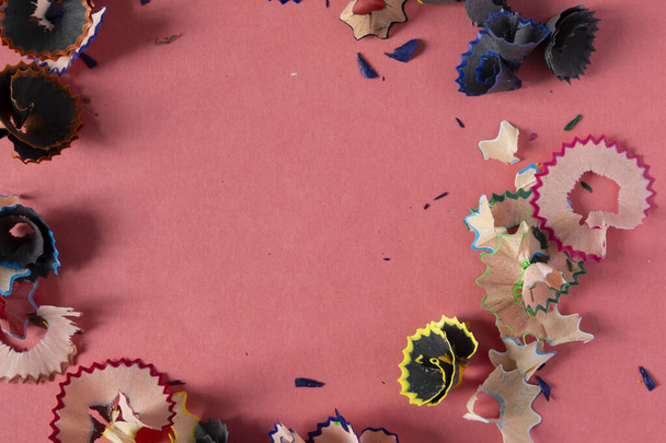 Forme de cercle faite avec des crayons de couleur copeaux. Copeaux de crayon en bois sur fond de papier pastel rose. Vue de dessus. Eléments de design pour affiche, bannière, cartes
 - Photo, image