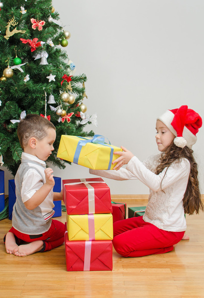 Hermano y hermana empaquetando regalos de Navidad
 - Foto, imagen