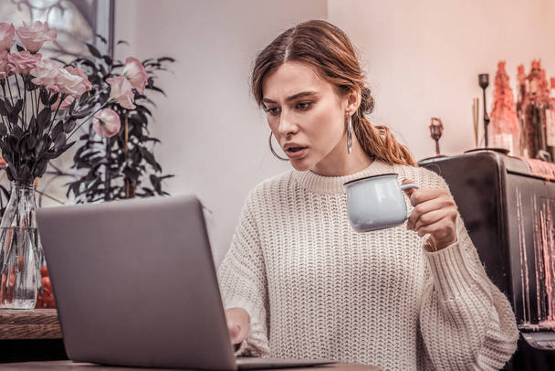 Shocked woman working on laptop in cafe - Photo, Image