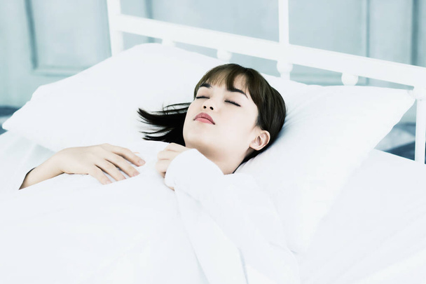 Asijky žena spát na bílém polštáři na posteli v ložnici v dovolené.happy relax čas. - Fotografie, Obrázek