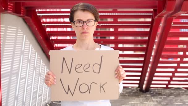 La femme tenant la signalisation avec le message du besoin de travail
 - Séquence, vidéo