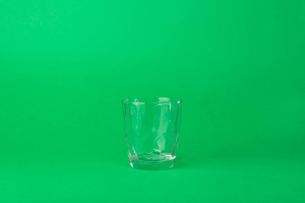 y vidrio facetado vacío sobre un fondo verde
 - Foto, imagen