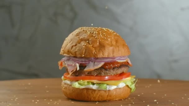 Wit sesamzaad dat in slow motion in een broodje valt. Bun met sesam voor het maken van hamburger. - Video