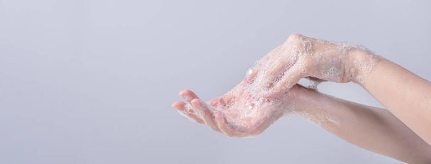 Washing hands. Asian young woman using liquid soap to wash hands, concept of hygiene to protective pandemic coronavirus isolated on gray white background, close up. - Φωτογραφία, εικόνα