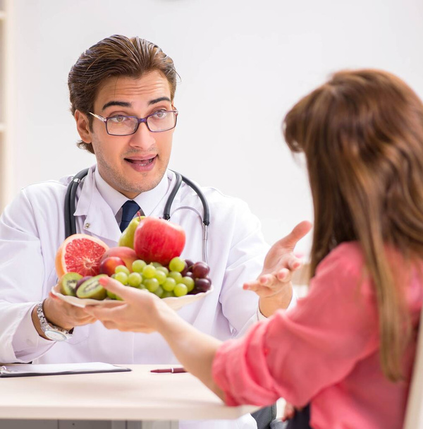 Mujer embarazada visitando al médico discutiendo dieta saludable
 - Foto, Imagen