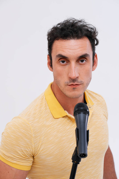 Studio portrait of excited man with a microphone against plain background.  - Fotó, kép