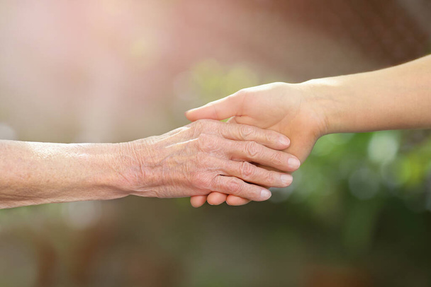 Helping hands. Hands of young adult and senior women. Elderly concept. - Foto, imagen