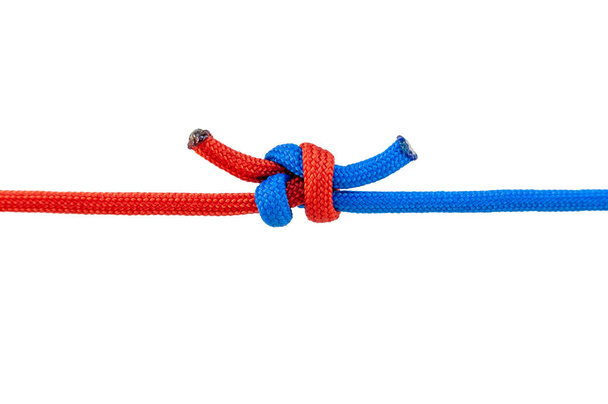 Two red and blue cords are connected . Knot on a cord isolated on a white background . - Foto, Bild