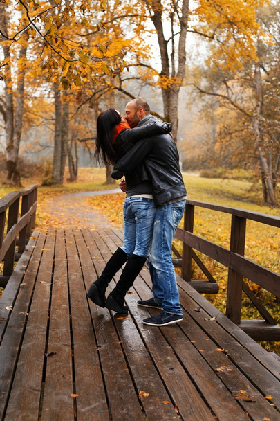 Happy middle-aged couple kissing outdoors on beautiful autumn day - Photo, Image