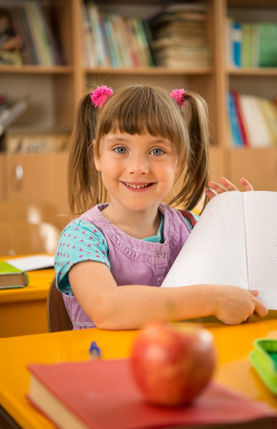 Маленька школярка сидить за шкільним столом під час уроку в школі
 - Фото, зображення