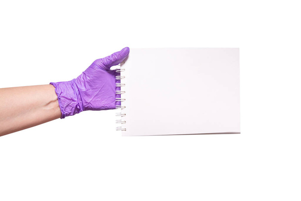 Hand in latex gloves holding paper notebook - Фото, зображення