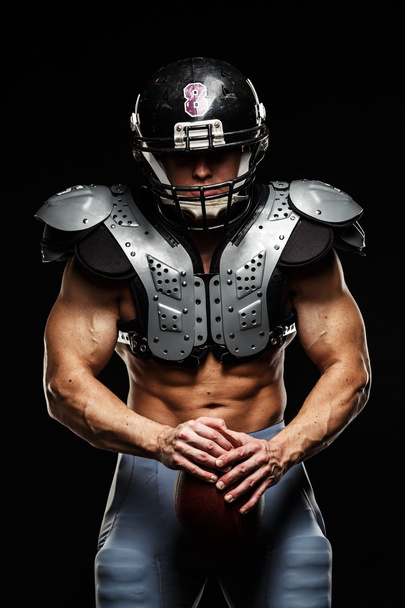 American football player with ball wearing helmet and protective shields - Fotografie, Obrázek
