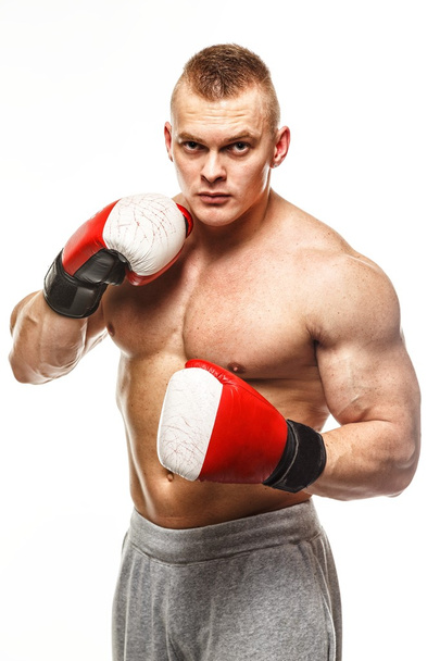 Komea lihaksikas nuori mies nyrkkeilyhanskat kädessä
 - Valokuva, kuva