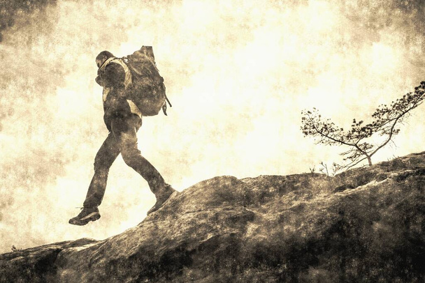Discovery Travel Destination Concept. Turista muž s batohem stoupá na vrchol hory proti Backdrop of Sunset Vintage Toned.. Kalotyp filtr. Starý styl fotografie. - Fotografie, Obrázek