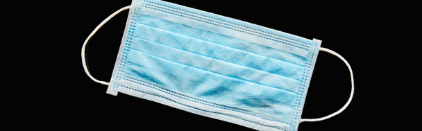 панорамный снимок синей медицинской маски, изолированной на черном
  - Фото, изображение