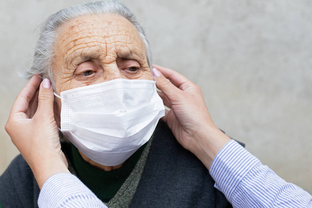 Portrait of elderly woman with chronic disease wearing protective mask because of covid-19 pandemic - Photo, image