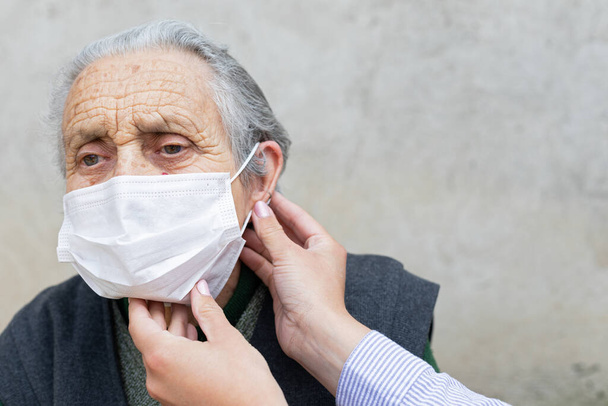 Portrait of elderly woman with chronic disease wearing protective mask because of covid-19 pandemic - Фото, изображение