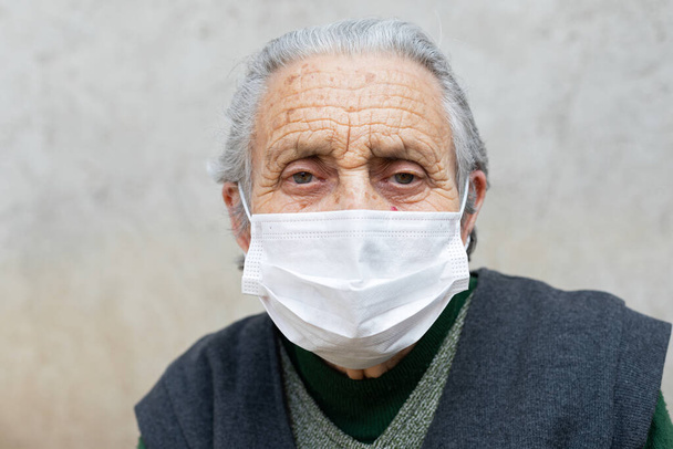 Portrait of elderly woman with chronic disease wearing protective mask because of covid-19 pandemic - 写真・画像