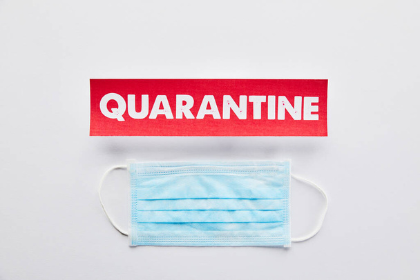top view of paper with quarantine lettering near medical mask on white  - Photo, Image