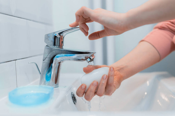 Vrouw wast zijn handen met zeep om infectie met coronavirus te voorkomen (COVID-19) - Foto, afbeelding