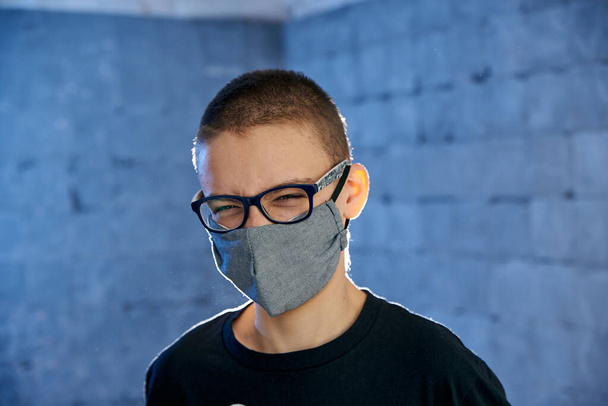 Funny boy teenager in a protective mask on his face from a virus - Zdjęcie, obraz